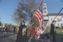 Jackie Kiernan carries the flag as the Sudbury Companies of Militia and Minute and the Sudbury Ancient Fyfe and Drum Companie march from Sudbury Town Hall to Concord